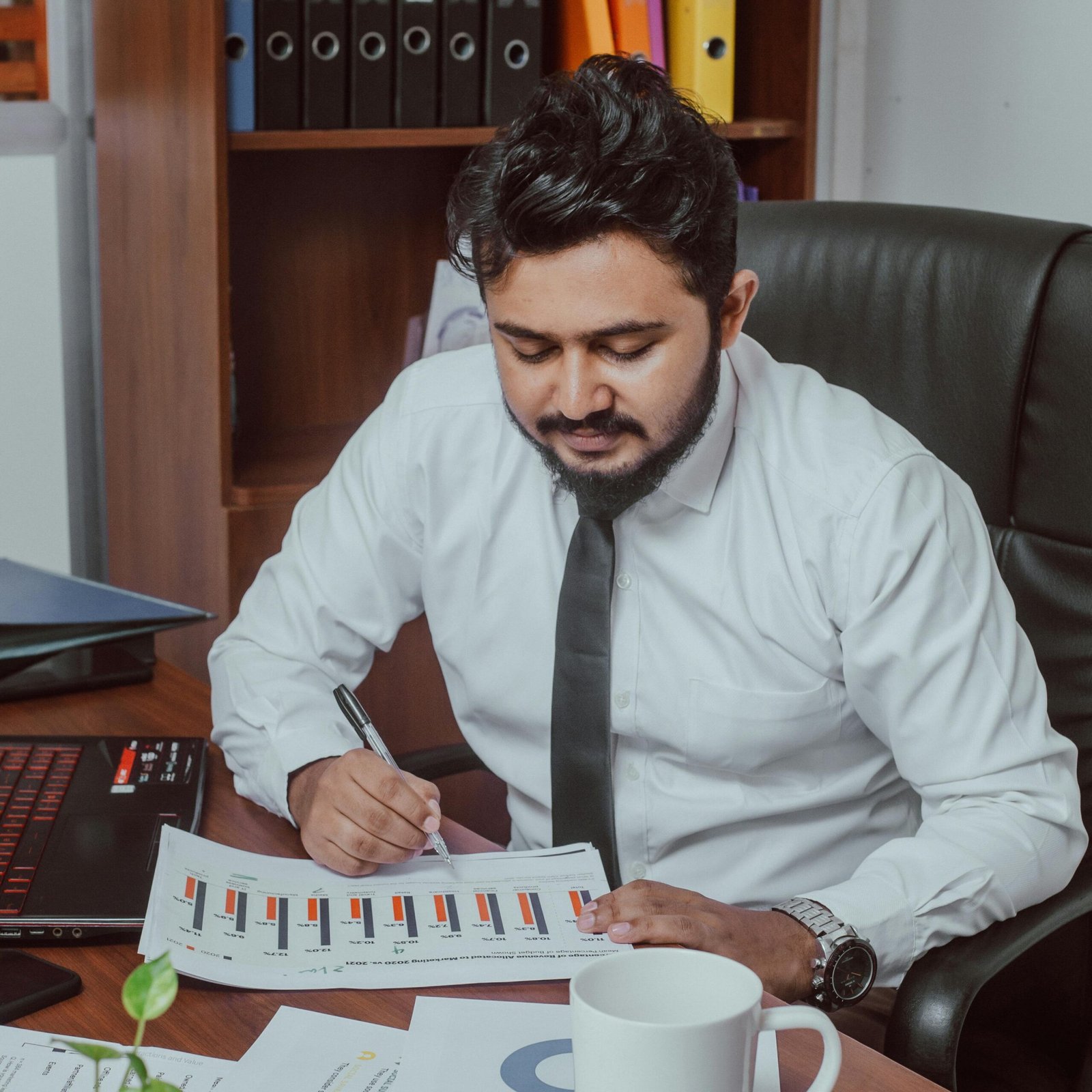 Business professional focused on analyzing financial documents in a modern office setting.